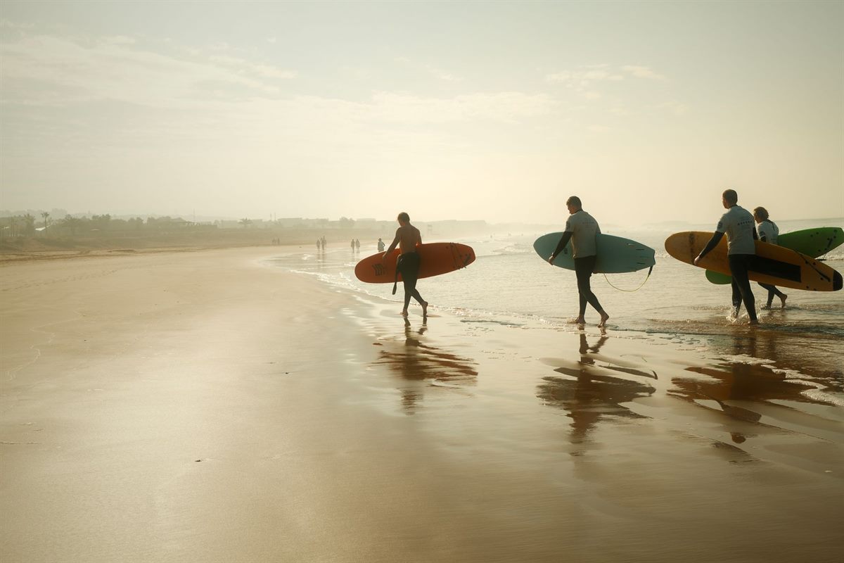 A group of surfers walking to the beach with surfboards at a surf camp in Taghazout, Morocco